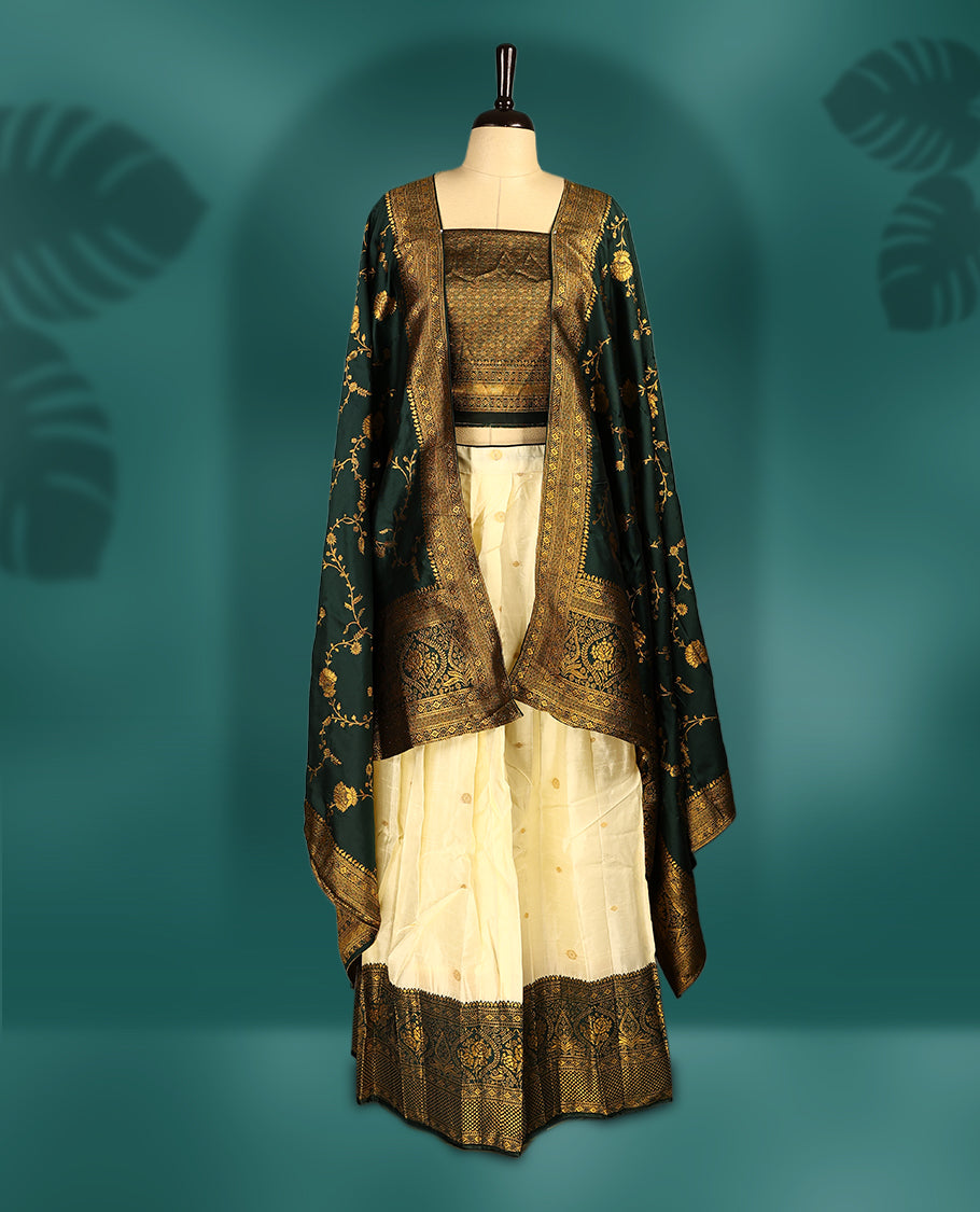Graceful Semi stitched cream and bottle green Dhavani set featuring a cream skirt with golden buttas and rich zari border, paired with a matching blouse and zari woven dupatta, perfect for weddings and festive occasions.