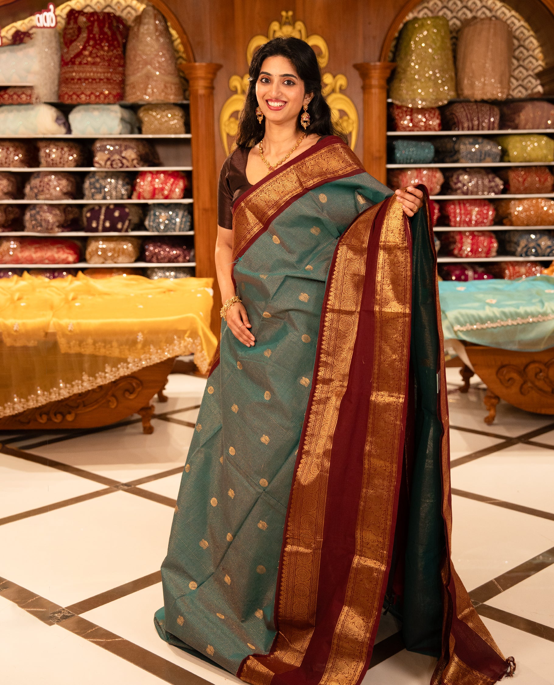 Teal with Brown Chettinad cotton saree featuring Gold zari strips with peacock motifs on body, complemented by contrast colour border with zari design & grand pallu, comes with matching blouse piece.