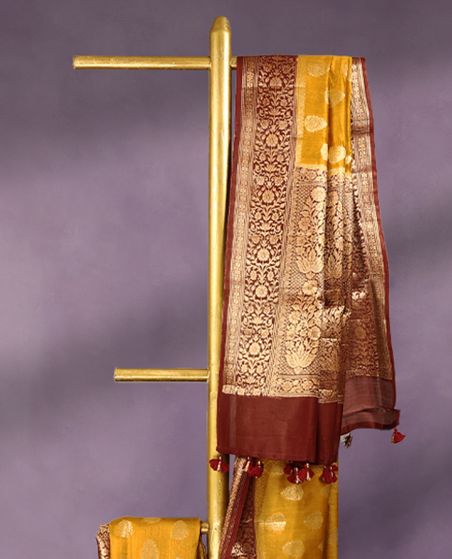 Mustard colour pure Banarasi Chanderi cotton fabric, featuring traditional antique zari buttas on the body, complemented by a traditional Maroon Colour border and a matching blouse.