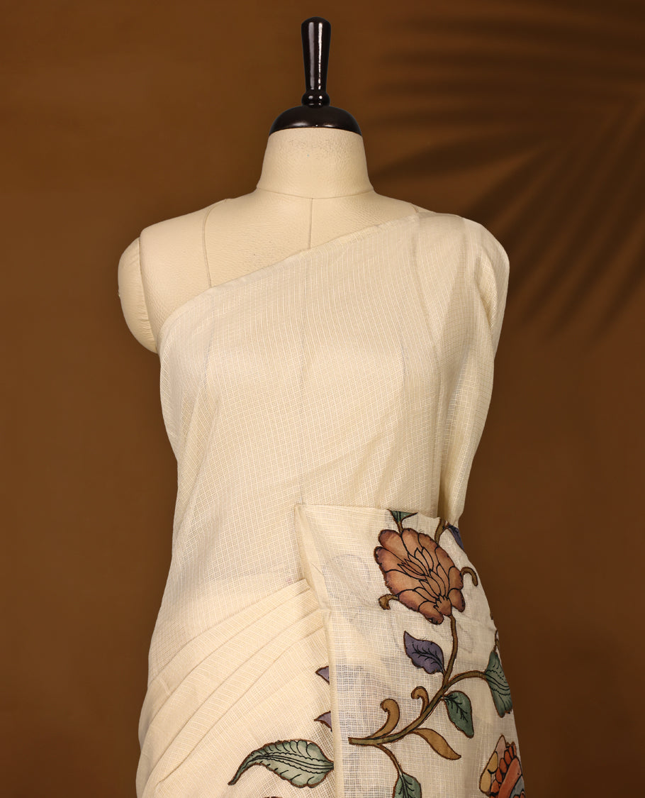 Elegant off white colour Kota net saree featuring intricate hand painted Kalamkari motifs on the pallu and floral accents on the pleats, blending tradition with artistry & Perfect for festive occasions and graceful styling.