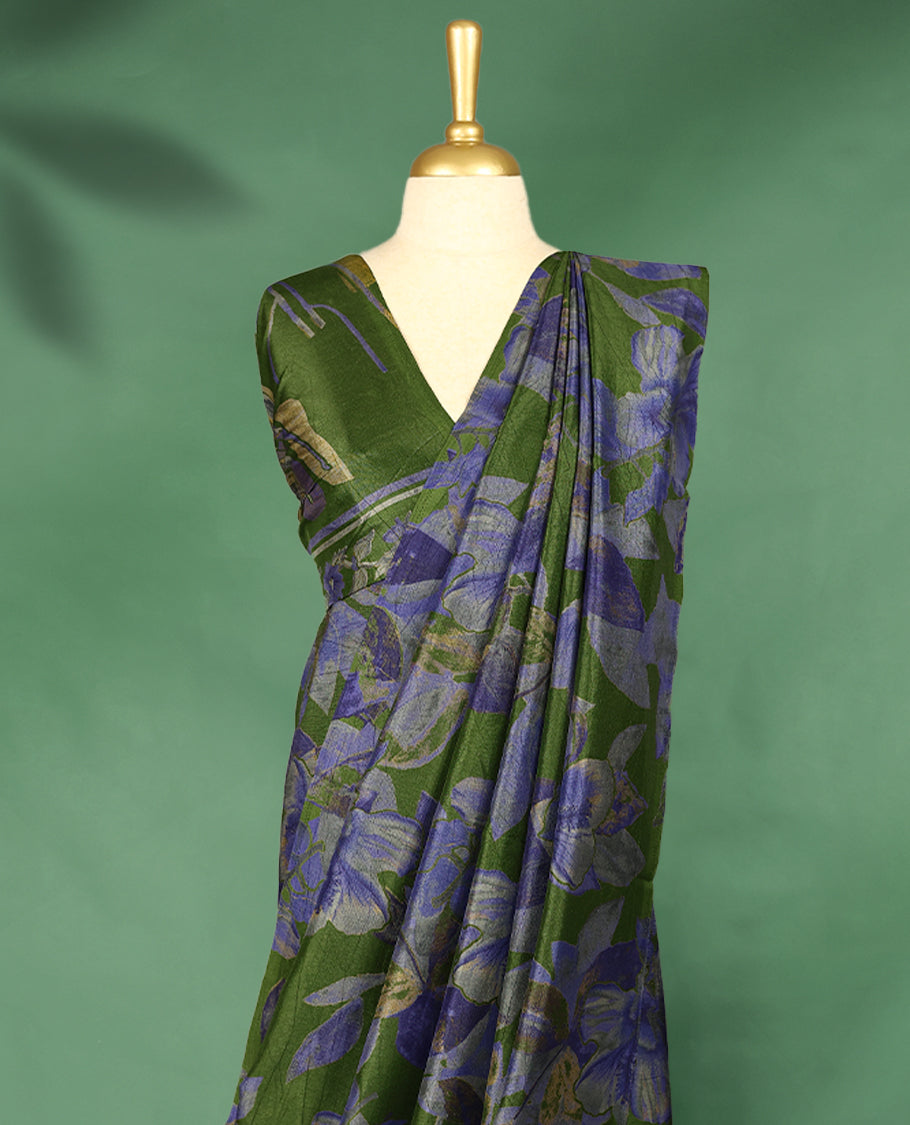 Deep olive green Colour Manipuri saree featuring oversized periwinkle blue and muted floral motifs, finished without a border, and paired with a matching blouse.
