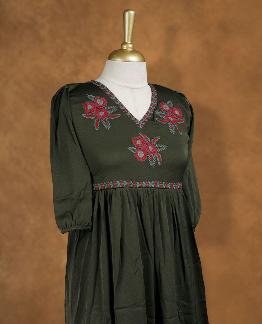 Olive green knee-length A-line dress with V-neckline, floral embroidery on yoke and hem, and elbow-length puff sleeves.