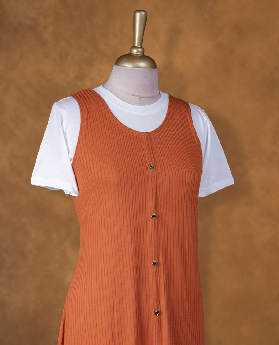 Rust orange sleeveless A-line midi dress with front button detailing, layered over a white crew-neck short-sleeve inner tee
