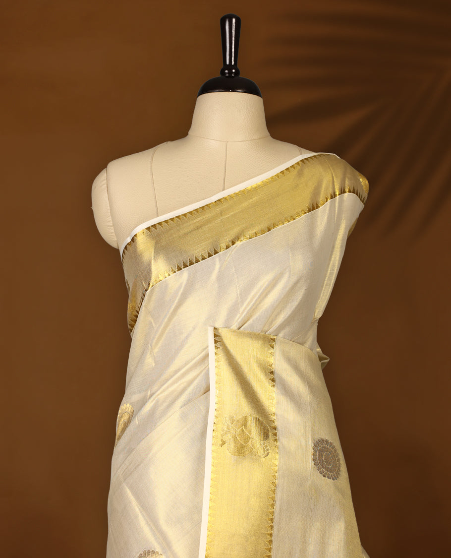 Elegant Light Gold colour Tissue Kerala saree featuring gold zari Chakram motifs on body, traditional golden zari kasavu border & Rich Pallu offering a classic and graceful look, paired with a matching blouse.