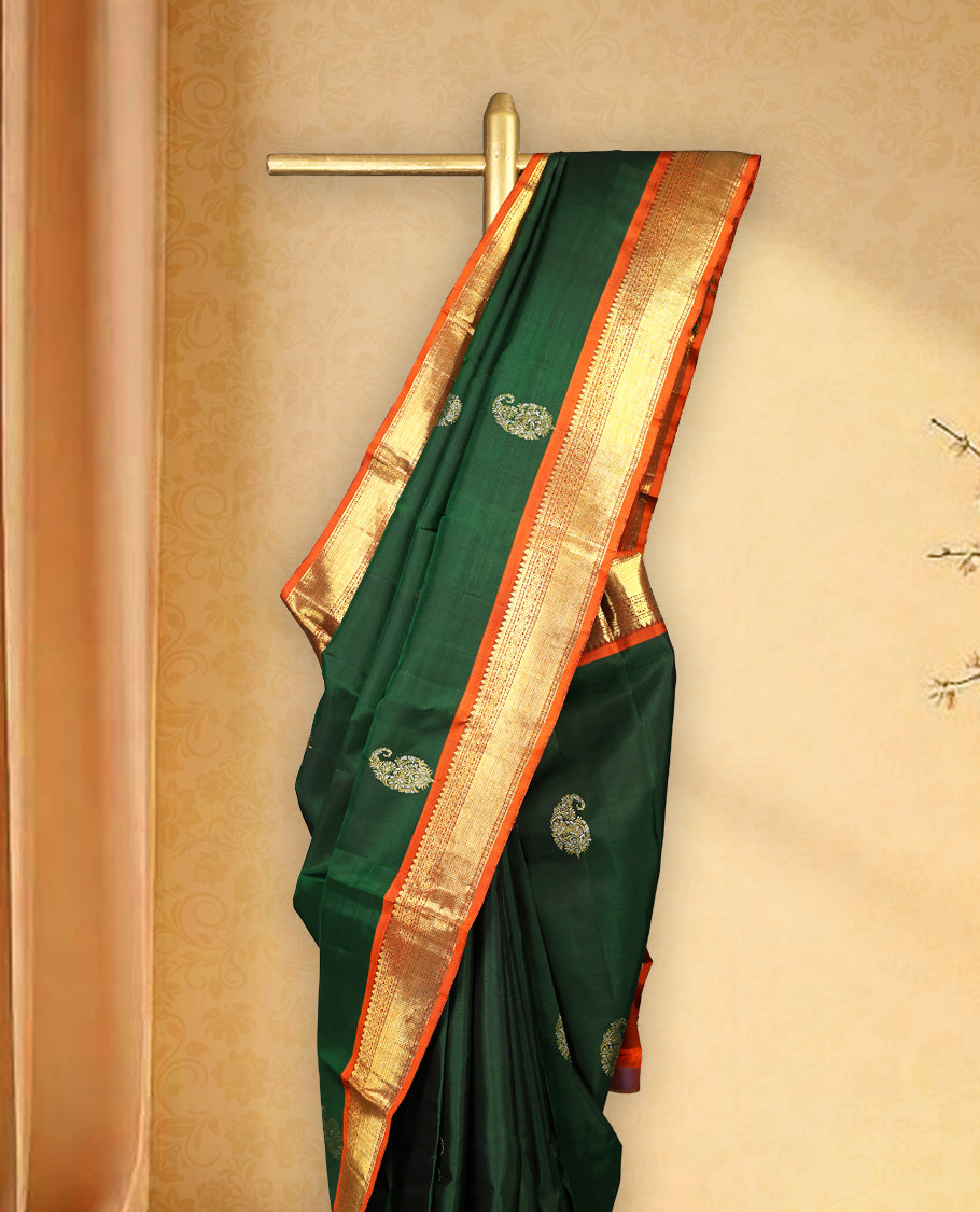 Bottle green colour pure Kancheepuram saree with gold zari traditional paisley motifs on the body contrast traditional border grand pallu with diamond pattern paired with matching blouse