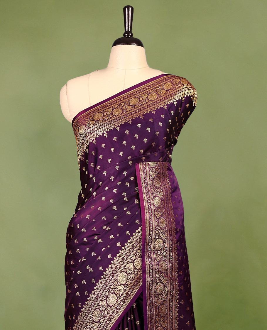 Grape wine colour semi Banaras satin crepe saree featuring gold zari woven small motifs across the body, complemented by an intricately designed traditional banarasi border and richly woven pallu, paired with a matching blouse piece.