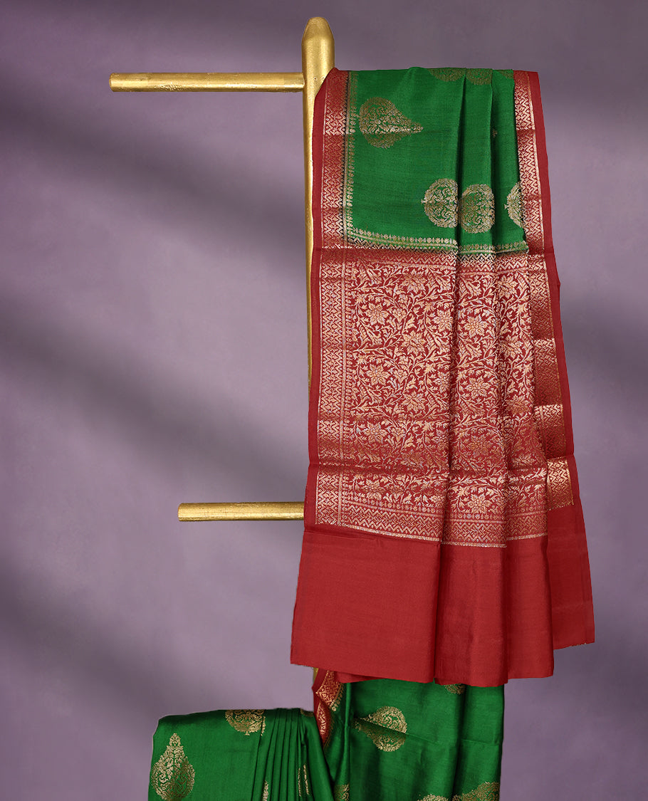 Dark Green Colour Pure Banaras Soft Silk Saree adorned with traditional antique zari motifs, paired with a hand dyed Dark Red antique style border and a matching blouse.