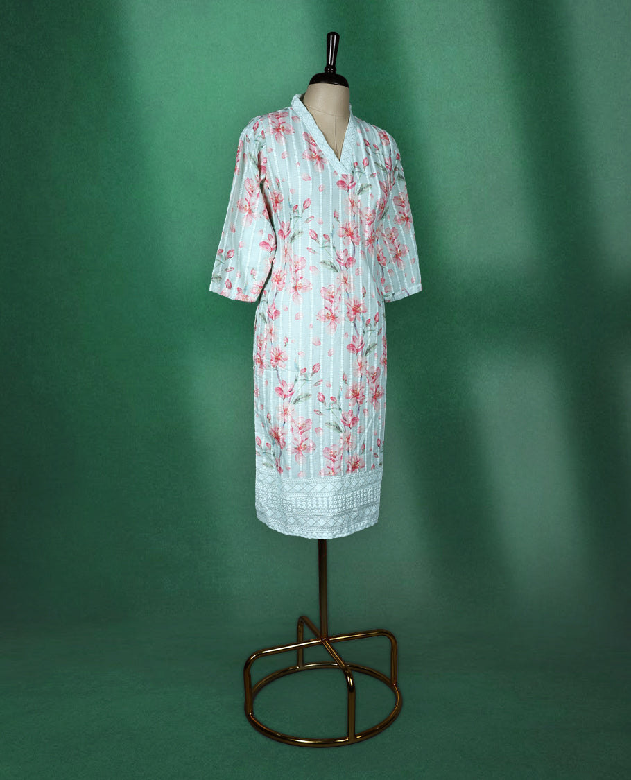 Mint green cotton kurti adorned with pink floral prints and white vertical stripes, featuring a V slit collared neckline, three quarter sleeves, and a white lace trimmed hem, fresh and feminine pick for everyday comfort.