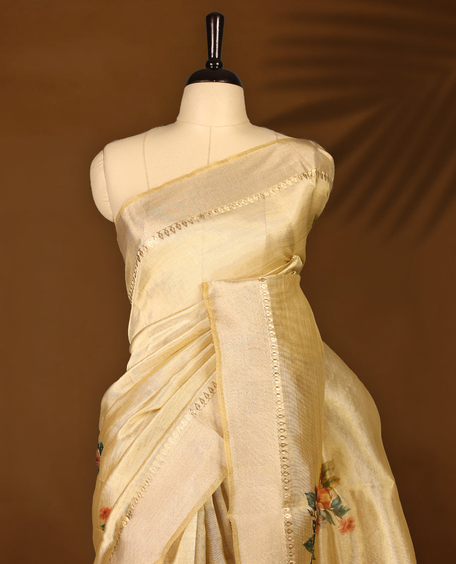 Light gold colour Organza Kerala saree featuring a smooth body with a subtle sheen, highlighted by a sleek golden zari border and delicate floral prints detailed with thread and sequence work near the pleats, Paired with a matching blouse.