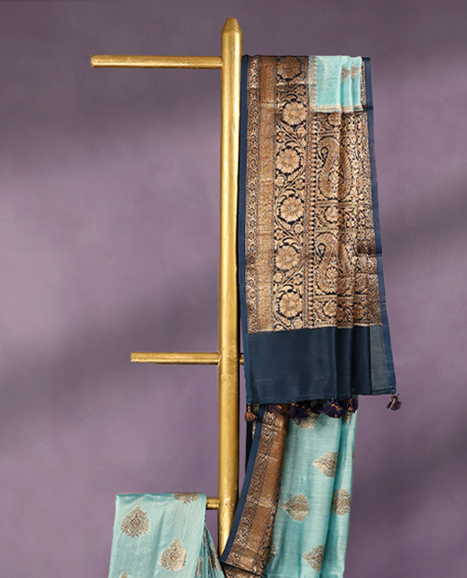 Sky Blue colour pure Banarasi Chanderi cotton fabric, featuring traditional antique zari buttas on the body, complemented by a traditional Indigo Blue Colour border and a matching blouse.