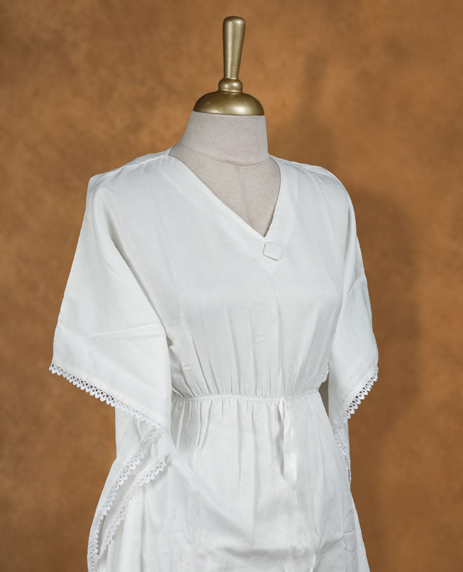 White kaftan-style nightwear dress with V-neckline, drawstring waist tie, relaxed draped sleeves, and delicate lace-detailed hem and edges.