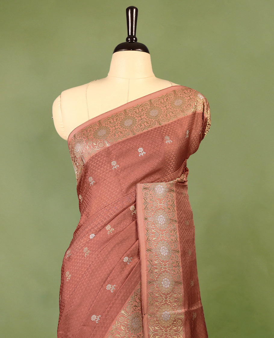 Deep Pastel Brown colour pure Banaras crepe saree showcases elegant silver zari Flower Motifs all over the body, a traditional Banarasi gold zari border, a rich intricately woven pallu, and comes with a matching blouse.