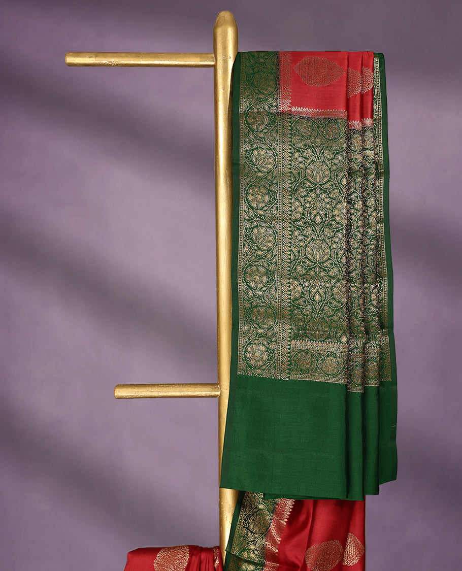Chilly Red Colour Pure Banaras Soft Silk Saree adorned with traditional antique zari motifs, paired with a hand dyed Dark Green antique style border and a matching blouse.