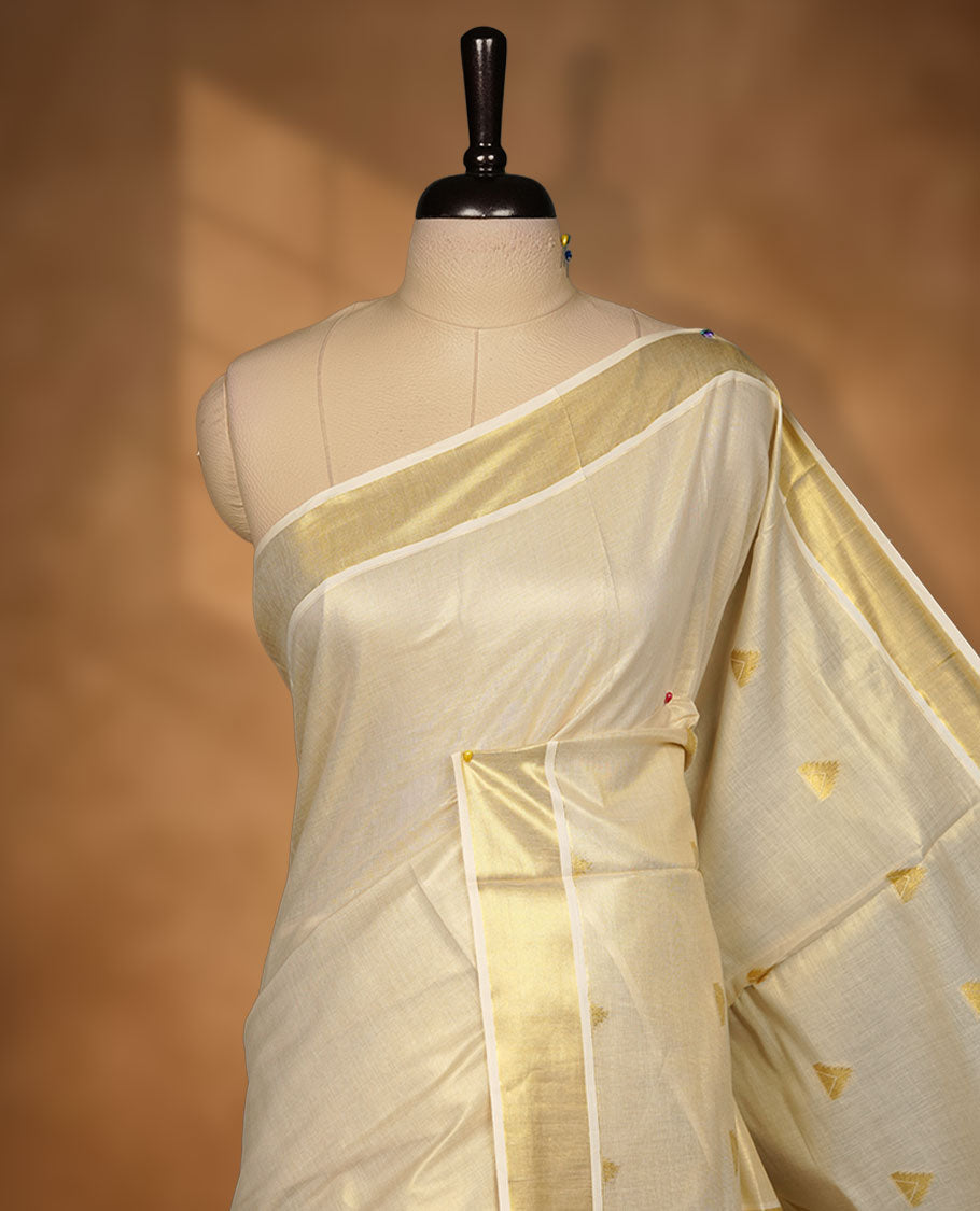 light gold tissue Kerala saree featuring delicate gold zari buttas across the body, a subtle kasavu border, and a finely woven traditional pallu, paired with a matching blouse