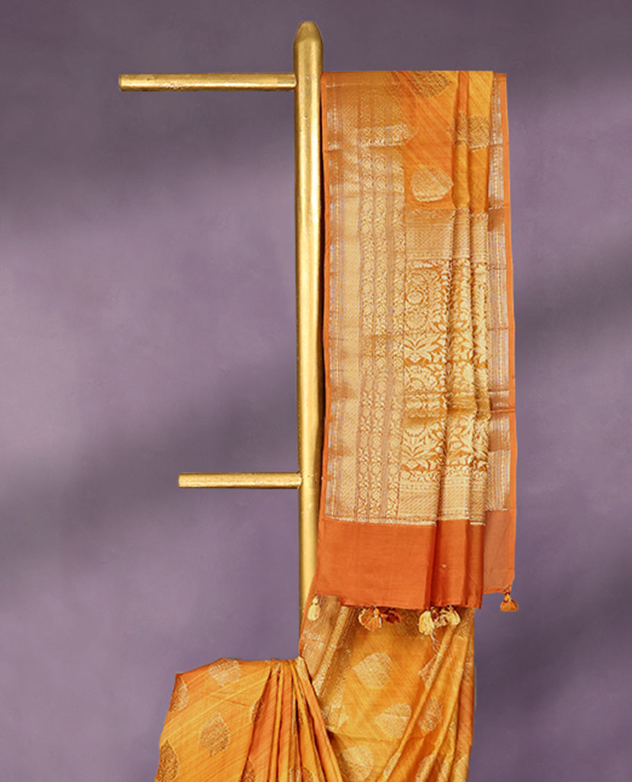 Mustard colour pure Banarasi Chanderi cotton, beautifully enhanced with hand-brushed colour and traditional antique zari butta motifs across the body, paired with traditional border and a matching blouse.