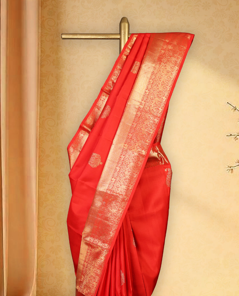 Red colour pure Kancheepuram saree with gold zari Banarasi mango motifs on the body, traditional border with elephant, floral, peacock and chackram motifs grand pallu with peacock and chackra pattern paired with matching blouse