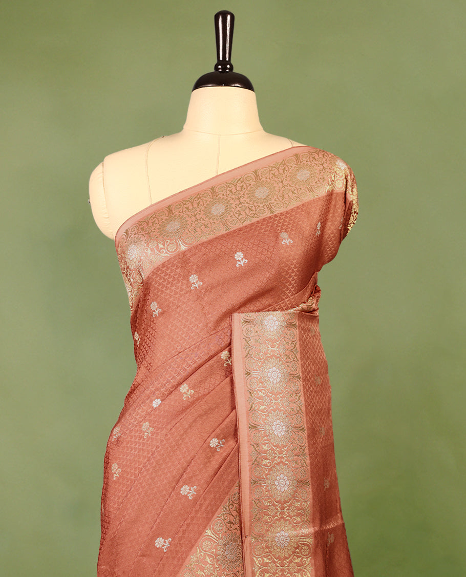Pastel Brown colour pure Banaras crepe saree showcases elegant silver zari Flower Motifs all over the body, a traditional Banarasi gold zari border, a rich intricately woven pallu, and comes with a matching blouse.