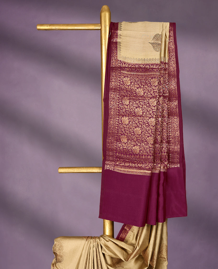 Beige Colour Pure Banaras Soft Silk Saree adorned with traditional antique zari motifs, paired with a hand dyed Dark Magenta antique style border and a matching blouse.