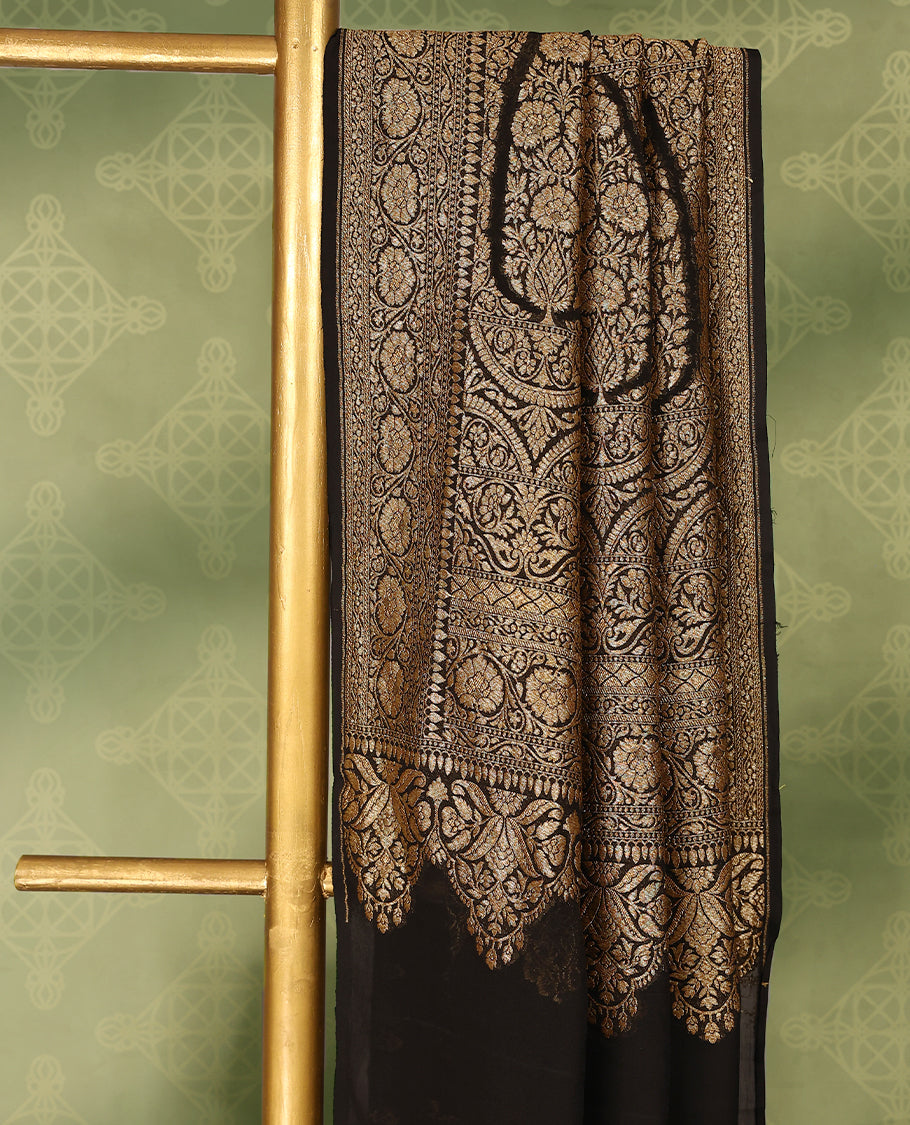 Black colour pure Banarasi georgette saree featuring gold zari Flower Motifs all over the body, complemented by an intricate gold zari Floral Kodi Worked border and pallu, with matching blouse.