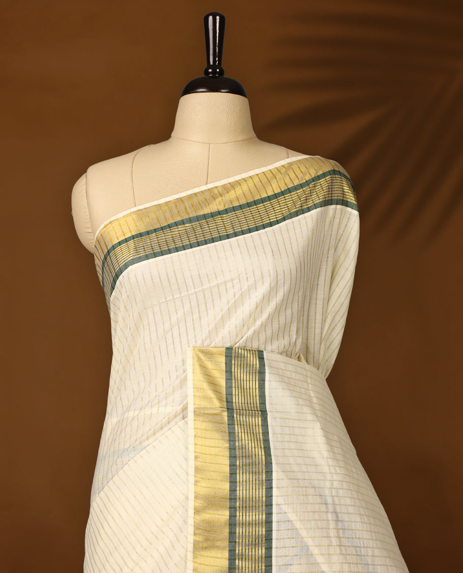 Elegant off white colour checked cotton Kerala saree with golden and green zari border, finished with tasselled pallu & Comes with a matching blouse, perfect for festive and traditional occasions.