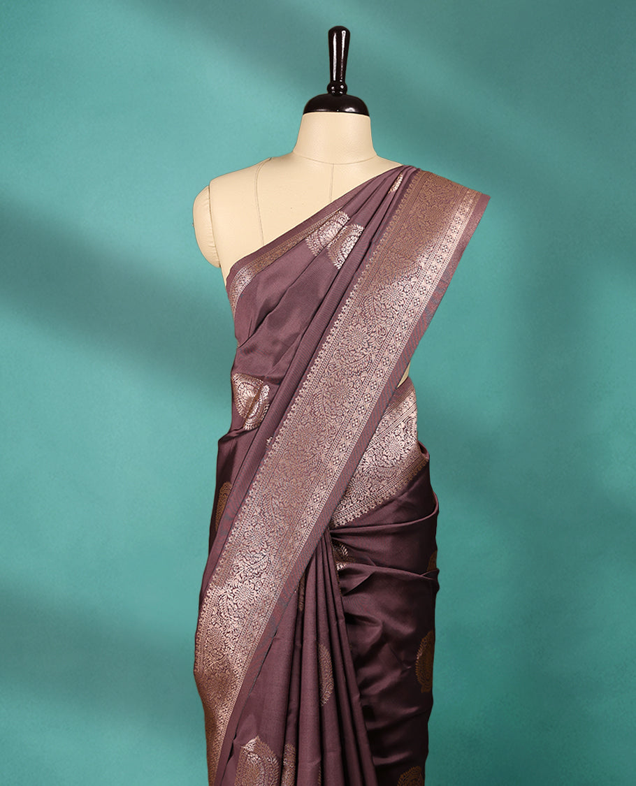 American Brown coloured semi silk saree featuring a Golden Zari Butta design on the body, paired with a Self coloured border and matching blouse.