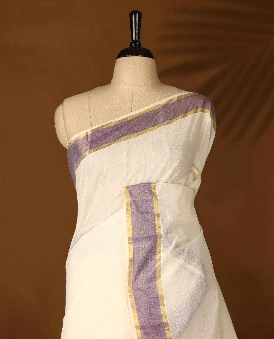 Elegant off white colour cotton Kerala saree featuring Plain body, Pastel purple & golden zari kasavu border offering a classic and graceful look, paired with a matching blouse.