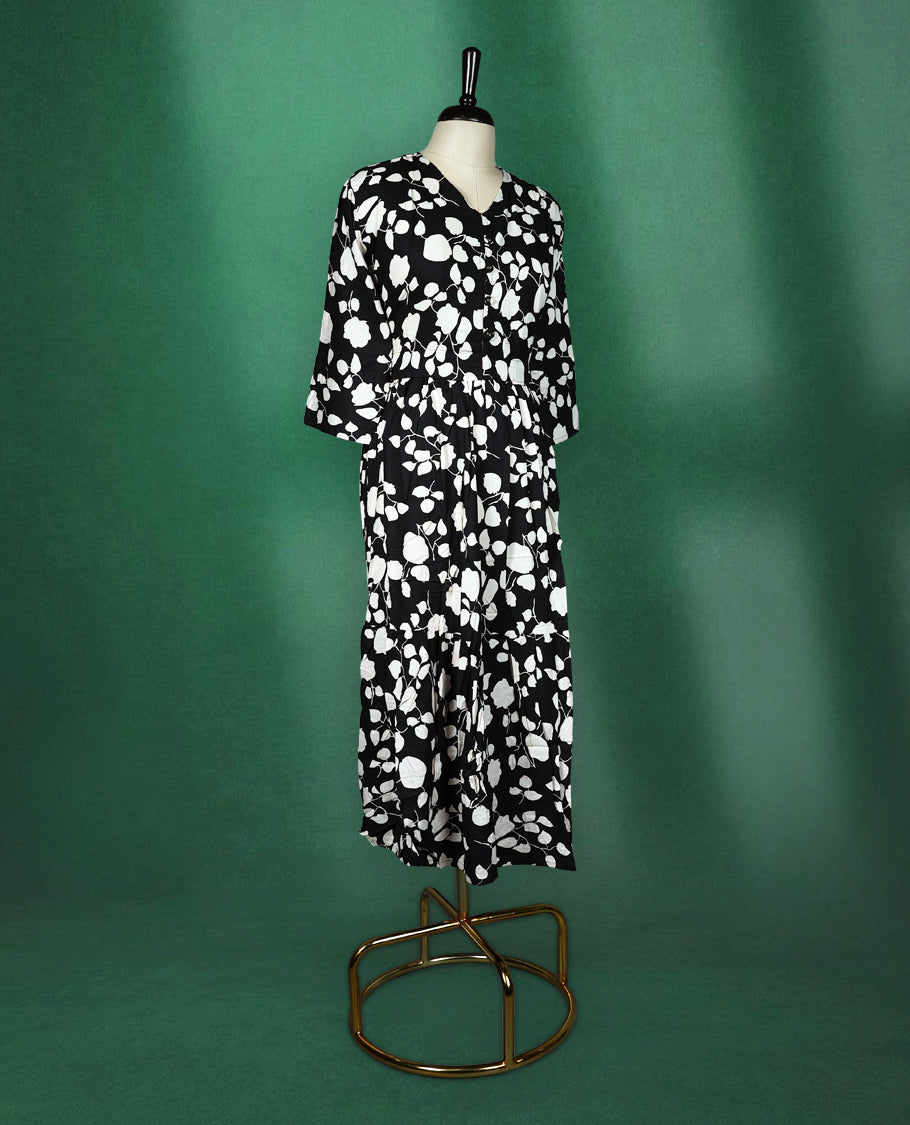 Black rayon kurti featuring bold white floral prints, designed with a V neckline, front button detailing, and a gathered waist, breezy and modern choice for casual wear.