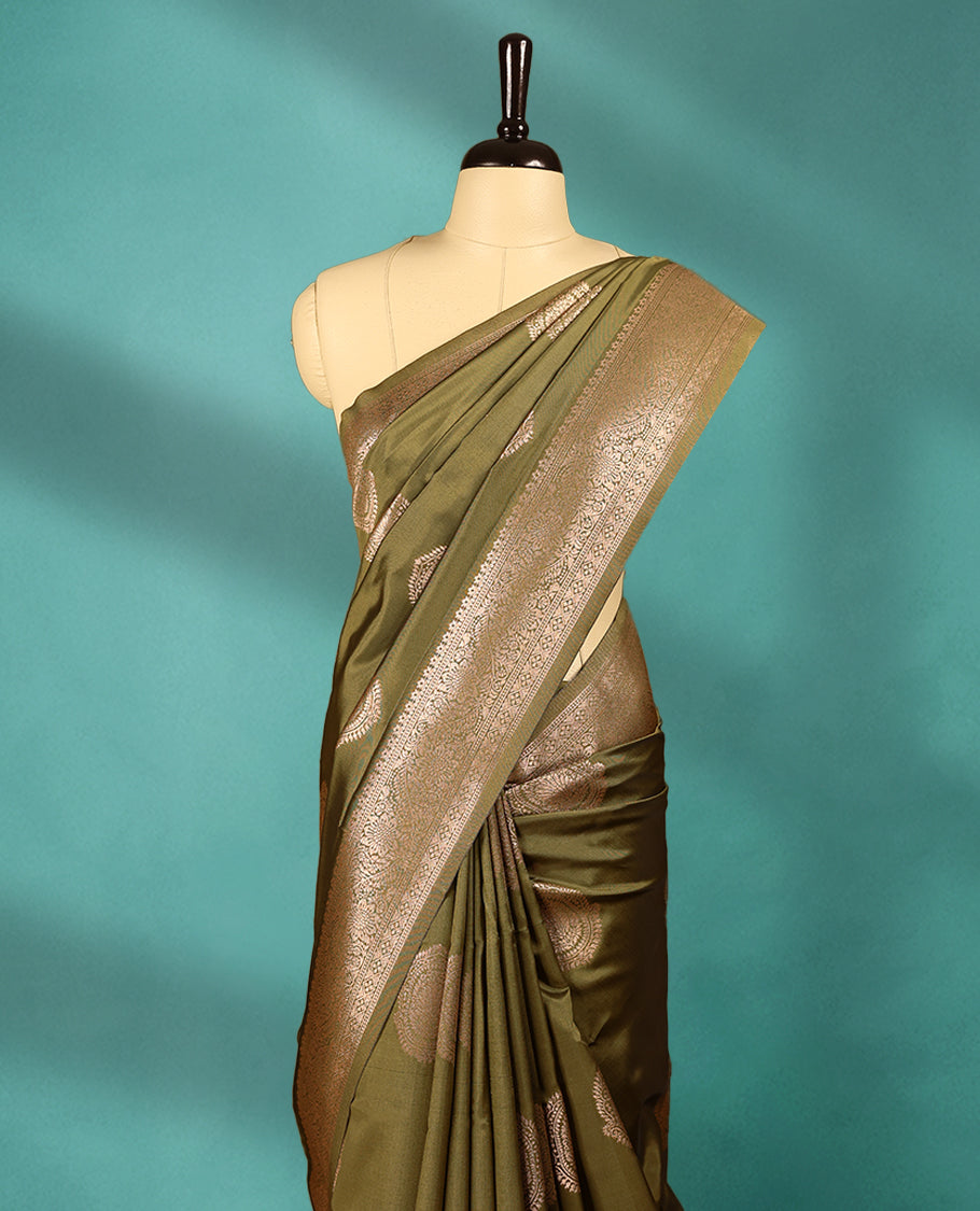 Olive Green coloured semi silk saree featuring a Golden Zari Butta design on the body, paired with a Self coloured border and matching blouse.