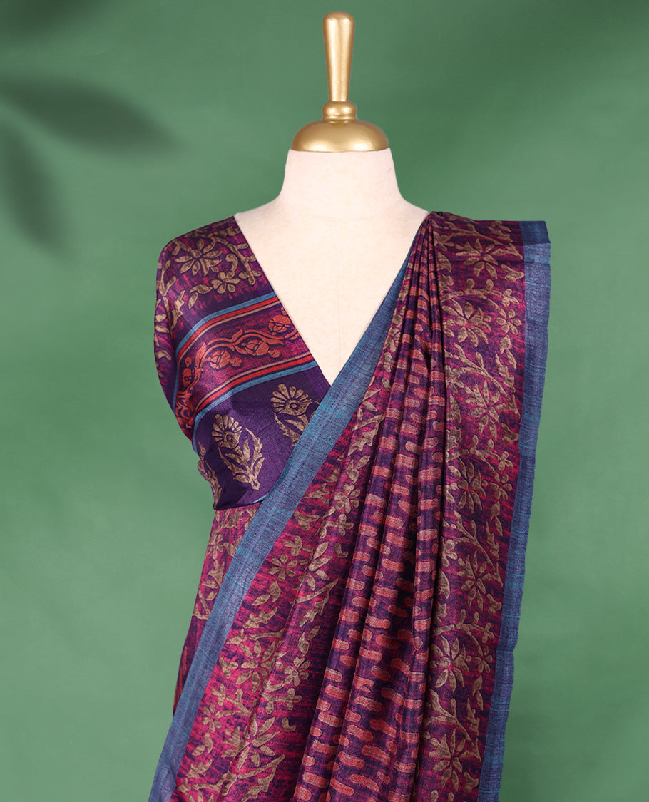 Plum purple colour Manipuri saree features a body with brick-red abstract motifs, highlighted by a contrasting indigo border and floral-printed pallu, and comes with a matching blouse.