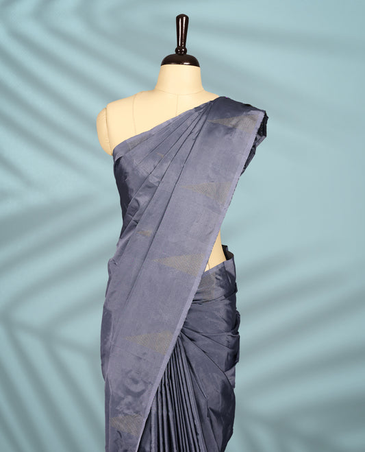 Rich grey toned semi silk saree features golden zari triangle patterns across the body, designed without a border, and comes paired with a matching blouse.