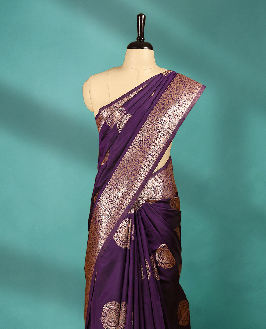 Royal Grape coloured semi silk saree featuring a Golden Zari design on the body, paired with a Self coloured border and matching blouse.