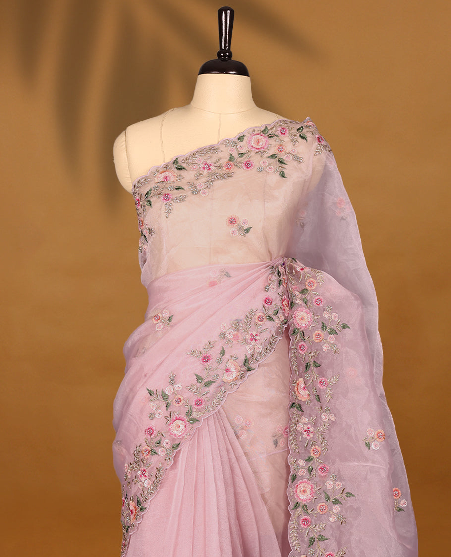 Pastel Pink Organza Tissue Silk Saree is beautifully adorned with intricate pink floral embroidery Border and a matching blouse.