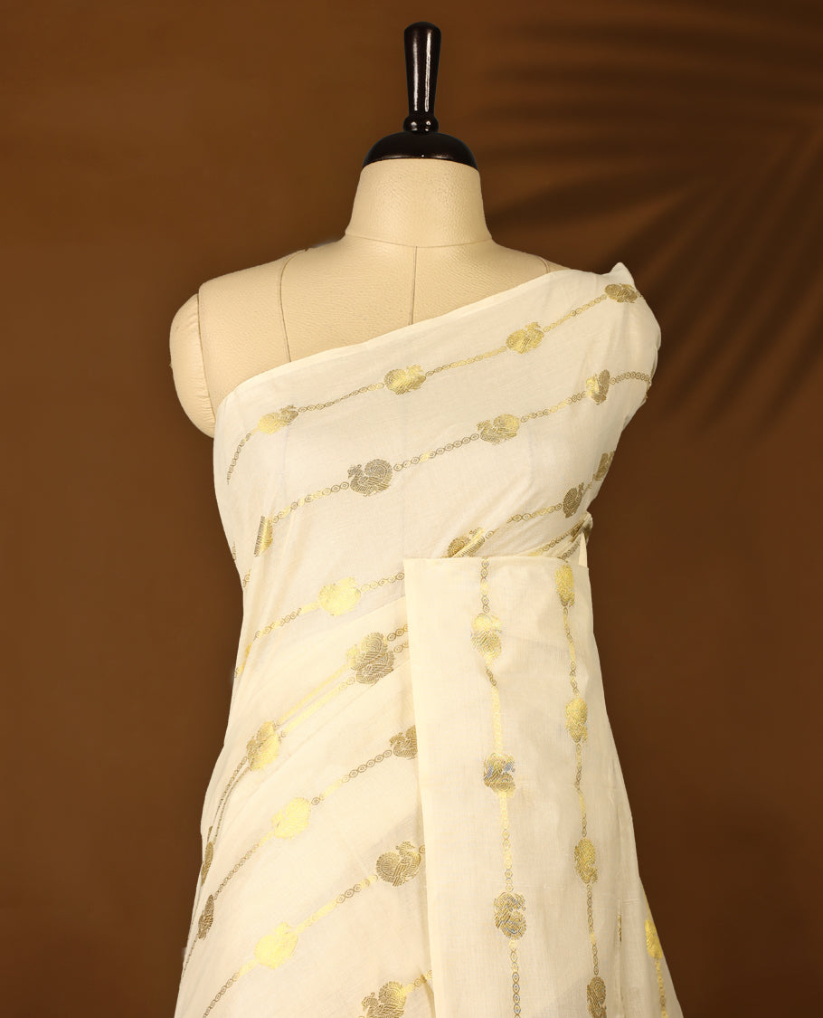 Elegant off white colour cotton Kerala saree featuring a gold Zari stripes with peacock motifs on body, with Blue colour tassels offering a classic and graceful look, paired with a matching blouse.