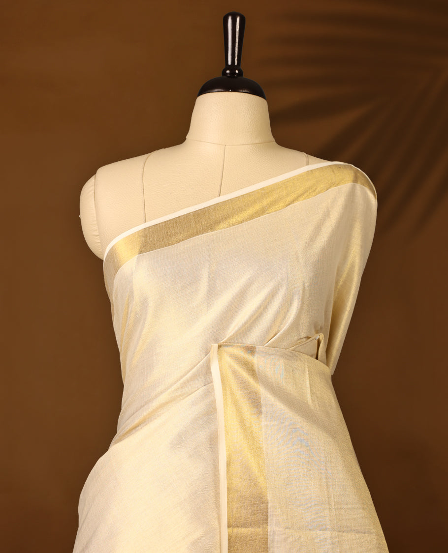 Elegant Light Gold colour Tissue Kerala saree featuring Plain body and traditional golden zari 2.5 Inch kasavu border offering a classic and graceful look, paired with a matching blouse.