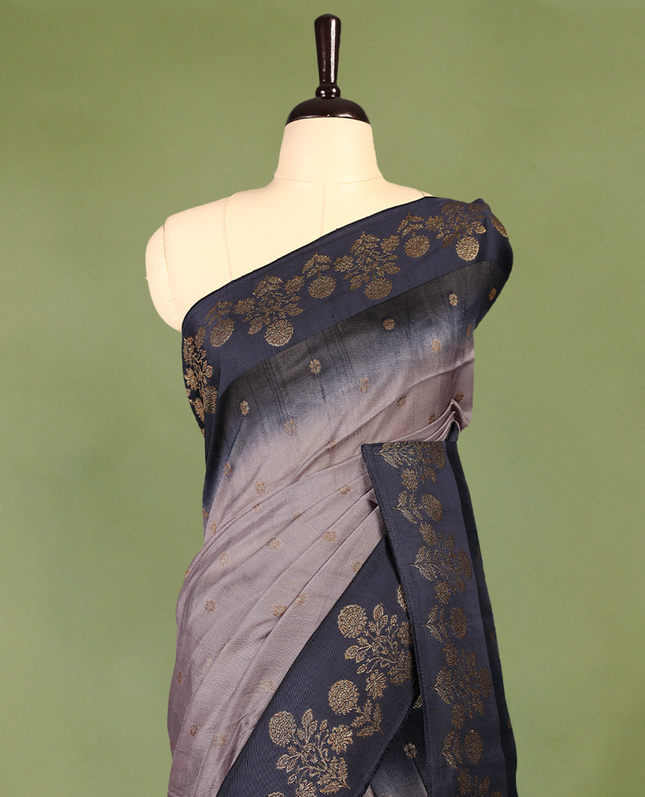 Grey and dark blue double shade semi Banaras Tussar Georgette saree adorned with elegant antique gold zari floral motifs across the body, featuring a detailed woven border and grand pallu, paired with a matching blouse piece.