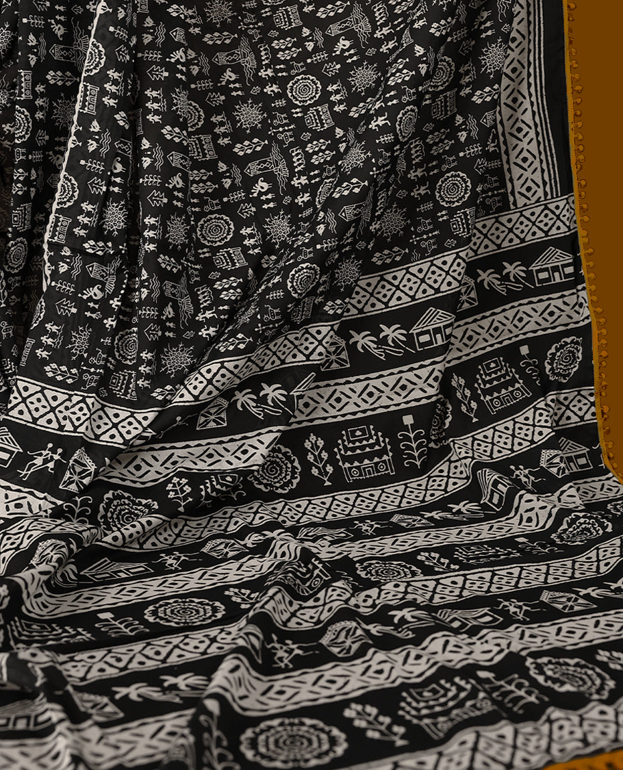 Black cotton saree features intricate white handblock prints, a beautifully detailed border with mustard piping and Self Coloured Blouse
