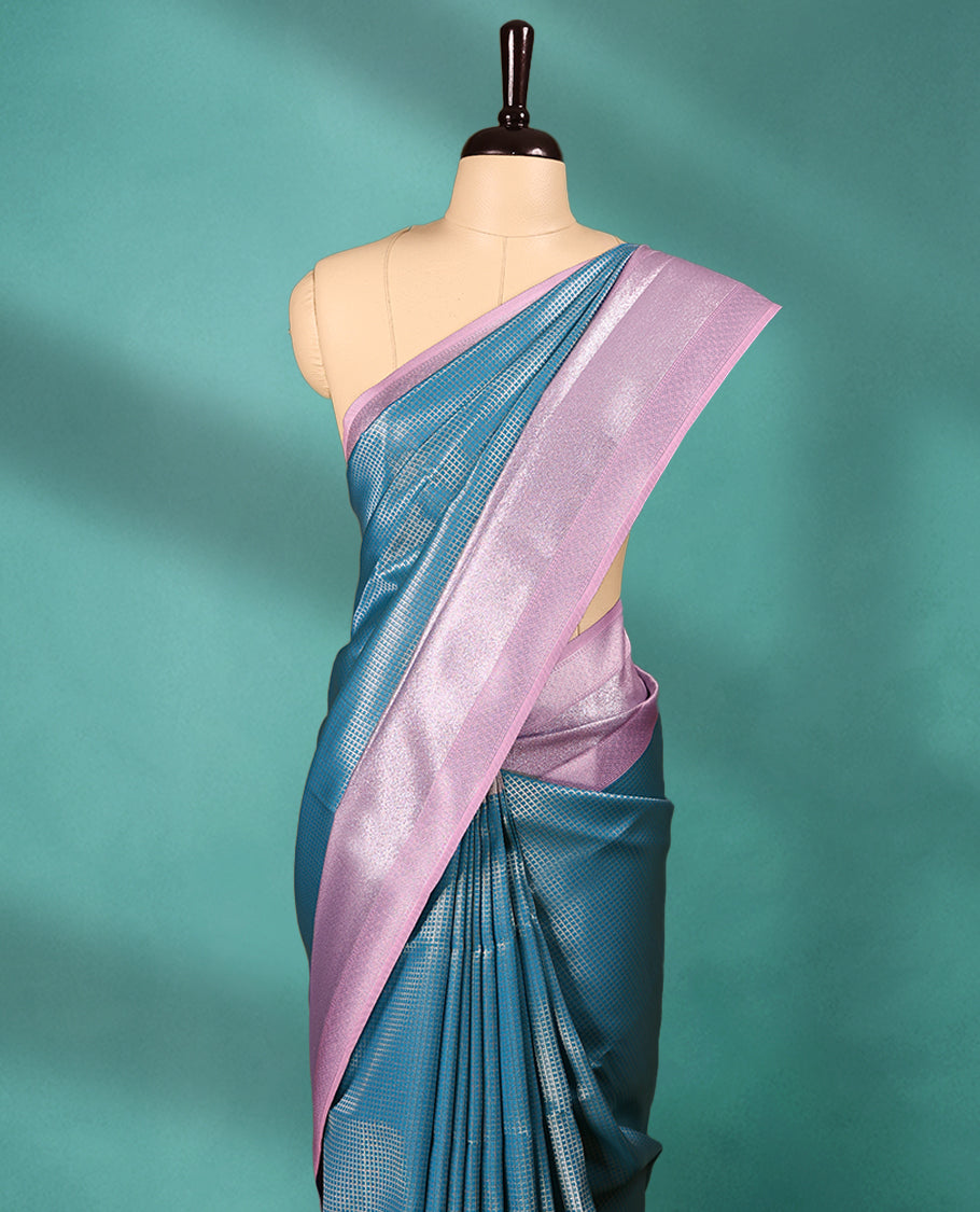 Blue coloured semi silk saree featuring a Check design on the body, paired with a Pastel Pink coloured border and matching blouse.