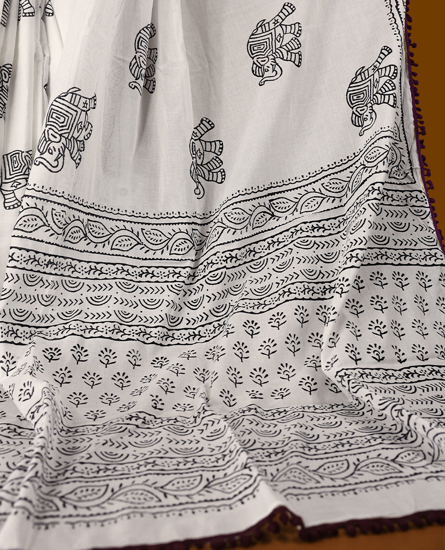 White cotton saree features intricate black elephant handblock prints, a beautifully detailed border with dark grape piping and Self Coloured Blouse