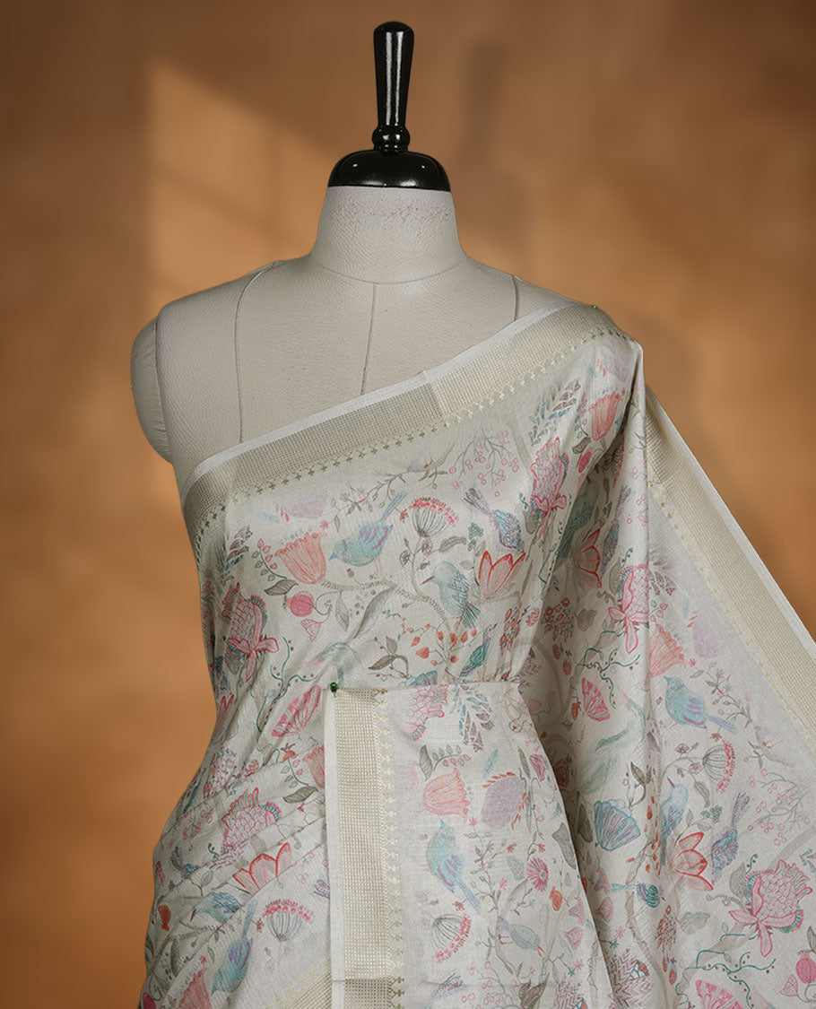 Cream colour semi tussar silk saree featuring all over floral and leaf motifs on the body with a subtle self border and tasselled pallu, paired with a matching blouse.