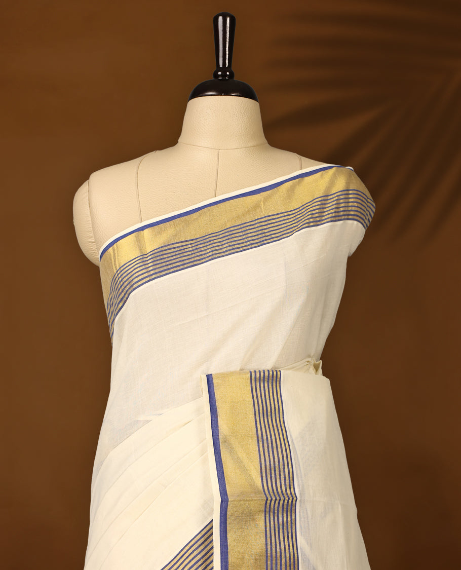 Elegant pure cotton Kerala saree with a cream base, golden zari border, and fine blue stripes & A perfect blend of tradition and simplicity, ideal for festive and cultural occasions and Paired with a matching blouse piece.