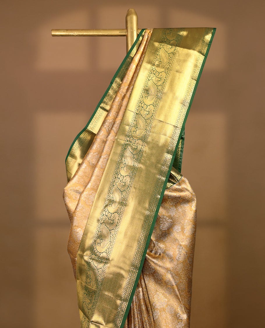 Gold colour tissue brocade saree with gold and silver zari lotus pattern on body, gold zari peacock and flower traditional green border, rich matching pallu with Antique zari motifs, paired with matching blouse.