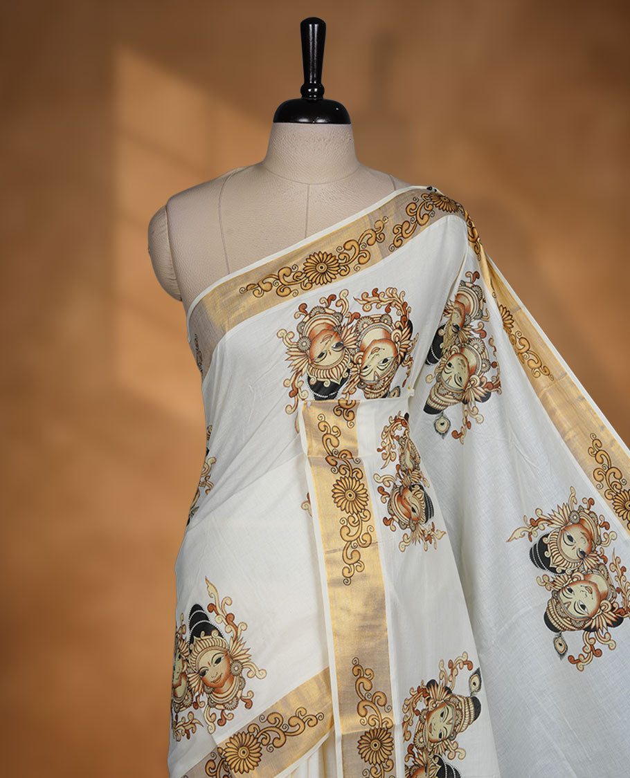 Off-white colour cotton Kerala saree featuring traditional Kathakali motifs on the body, complemented by a golden zari border and classic pallu, paired with a matching blouse.
