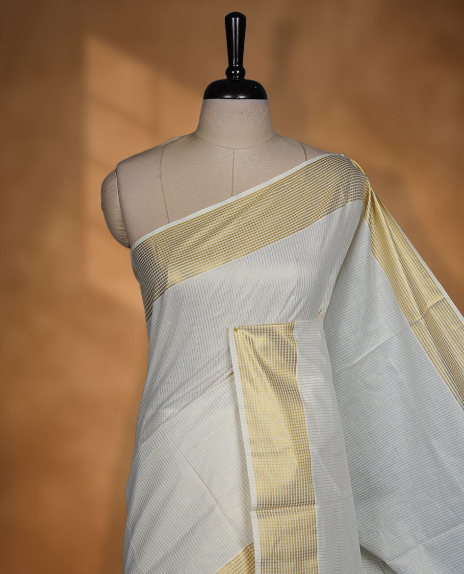 Off white colour Kerala cotton saree featuring fine golden stripes, complemented by a classic zari border and traditional pallu, paired with a matching blouse.