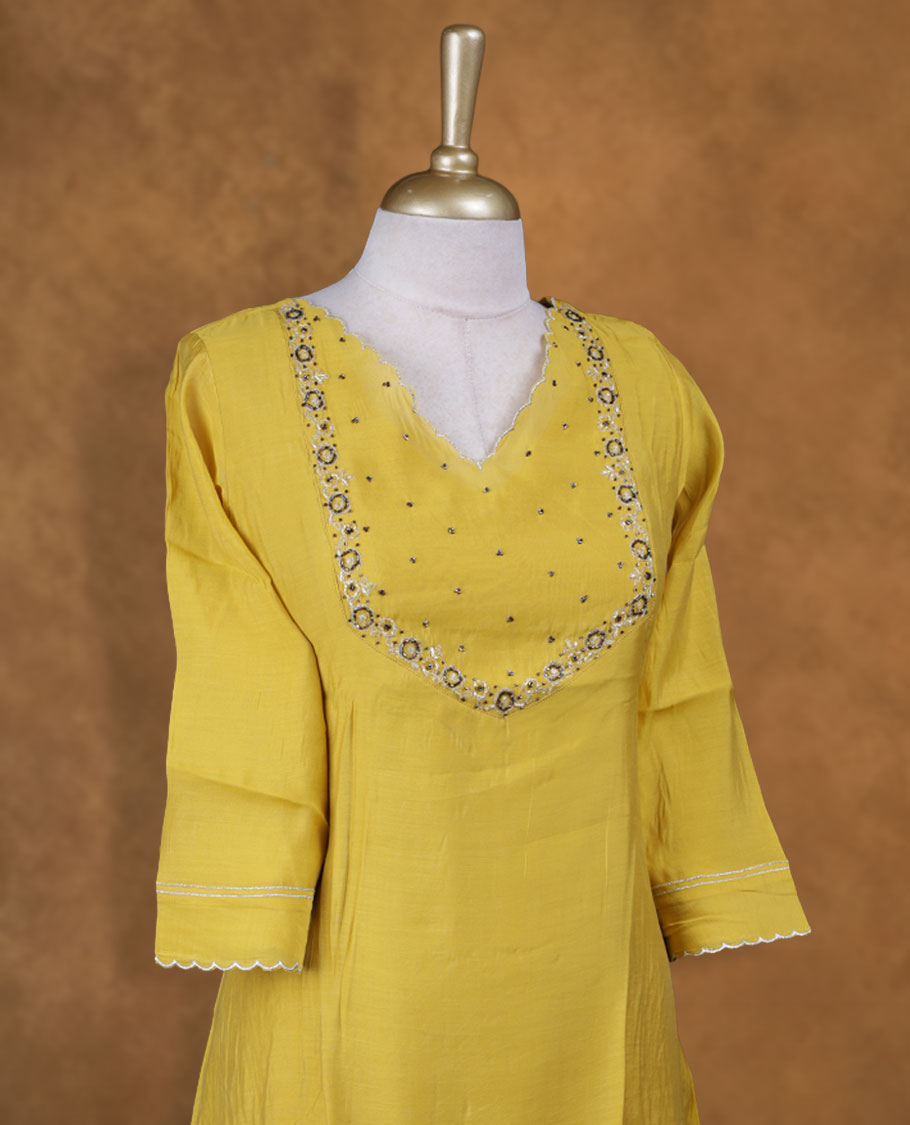 Yellow colour kurti with styled with a cut beats pattern around neckline, knee length design, and a sleeve .