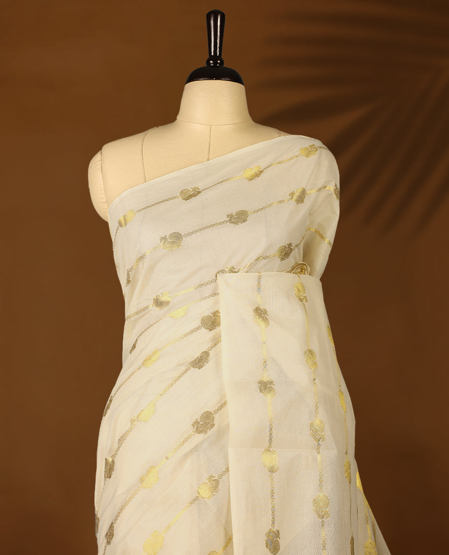 Light Gold colour Tissue Kerala saree featuring Gold zari Stripes with Peacock motifs on body, with Black colour tassels with a matching blouse perfect for festive occasions.