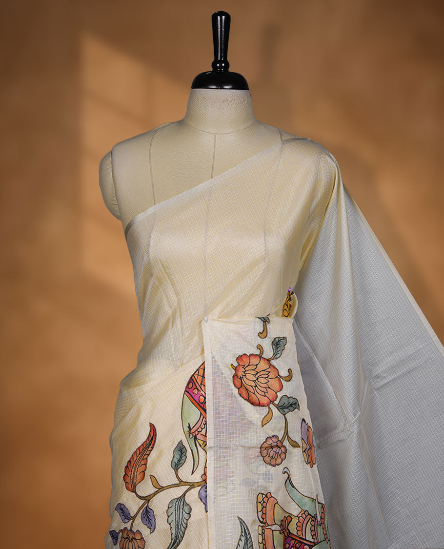 Cream off-white semi tusser silk saree featuring artistic floral and elephant motifs on the pallu with subtle contrast detailing along the border, paired with a matching printed blouse.