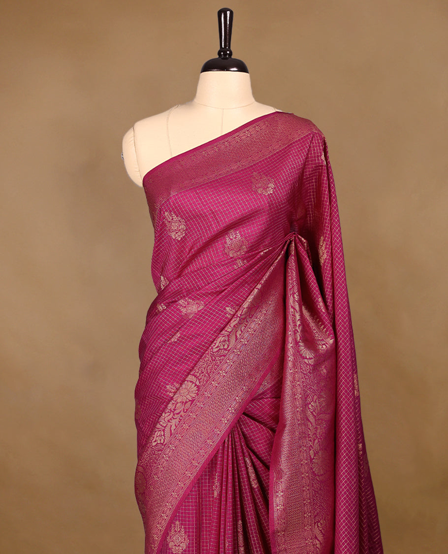 Rani Pink coloured semi Banaras georgette saree featuring golden Zari checks with floral motifs on the body, complemented by a self coloured traditional border with floral kodi design and a matching blouse.