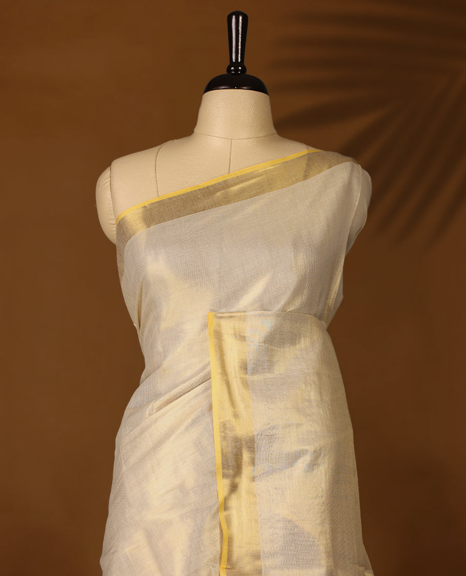 Elegant Light Gold colour Tissue Kerala saree featuring Plain body and traditional Muted golden zari kasavu border offering a classic and graceful look, paired with a matching blouse.