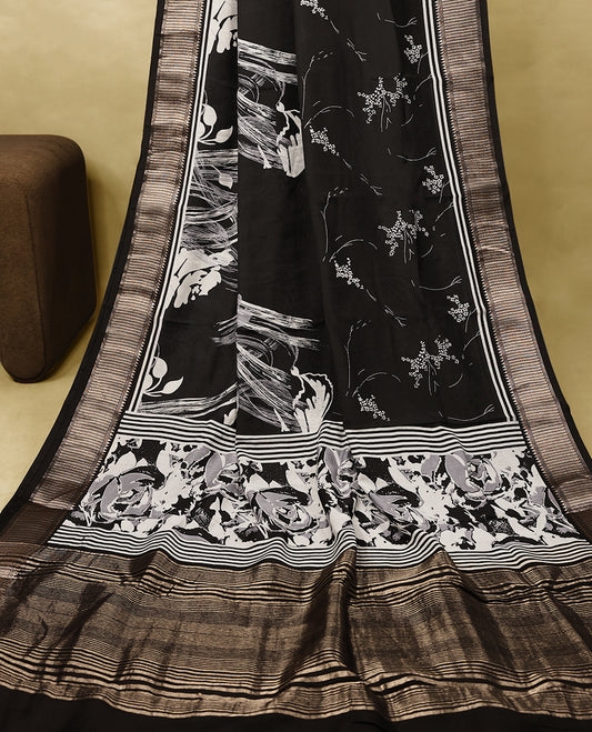 Black colour Viscos semi printed saree featuring a golden zari border, abstract white printed motifs on the body, and comes with a matching blouse