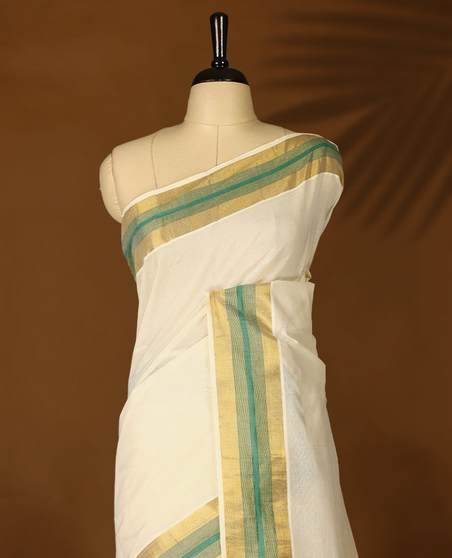 Elegant off white colour cotton Kerala saree featuring Plain body, Green colour & golden zari kasavu border offering a classic and graceful look, paired with a matching blouse.